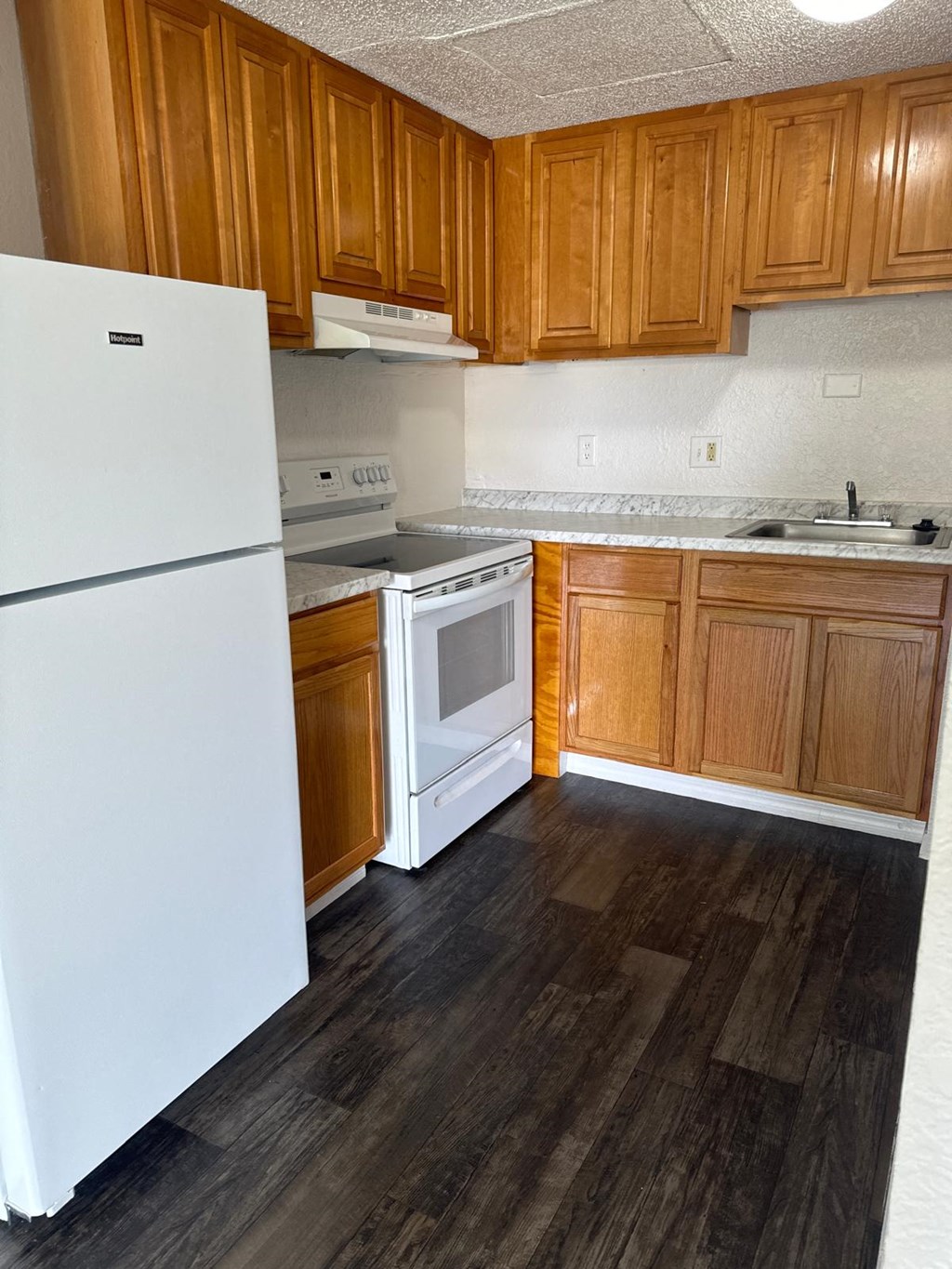 a kitchen with white appliances and wooden cabinets