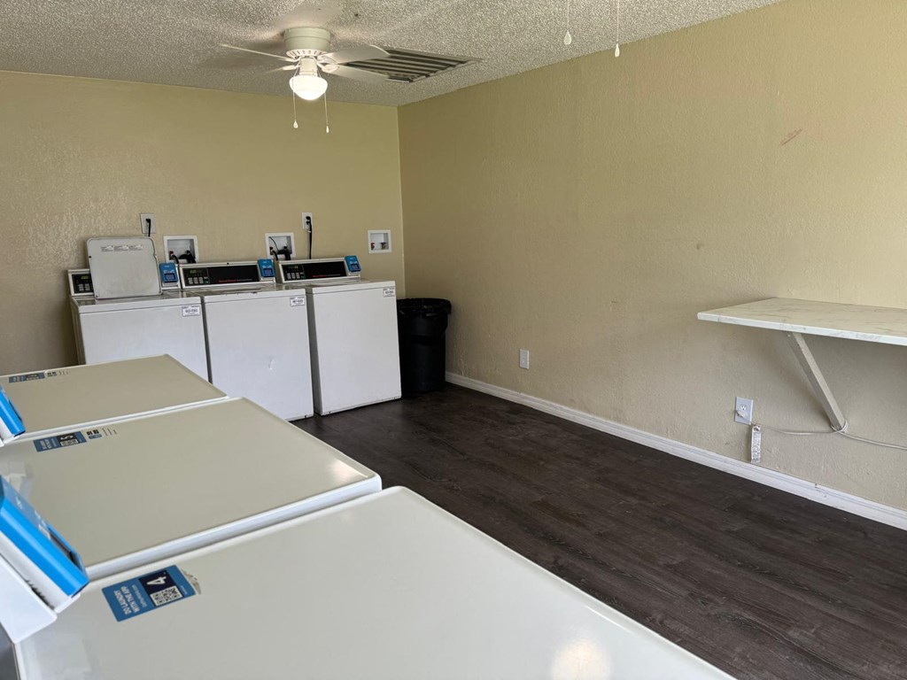 a kitchen with white appliances and a wood floor