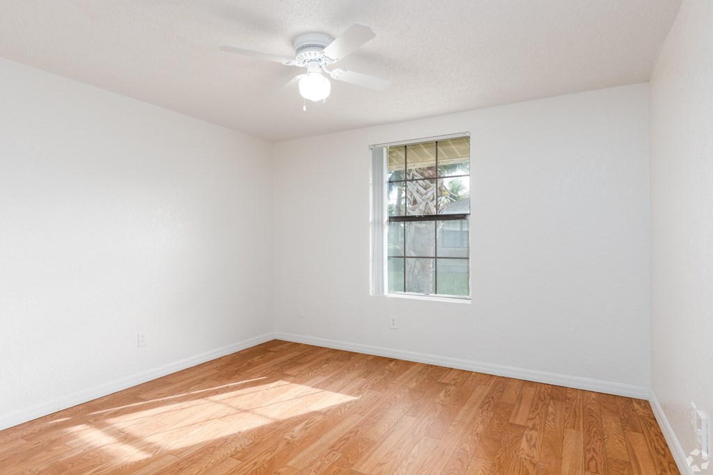 A room with a ceiling fan and a window.