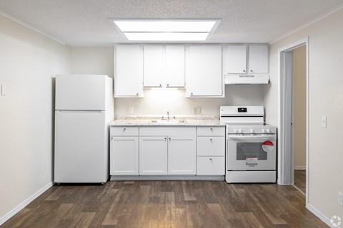 A kitchen with white appliances and cabinets.