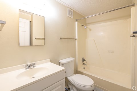 A bathroom with a toilet, sink, and shower.