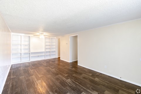 A room with wooden flooring and a white wall.