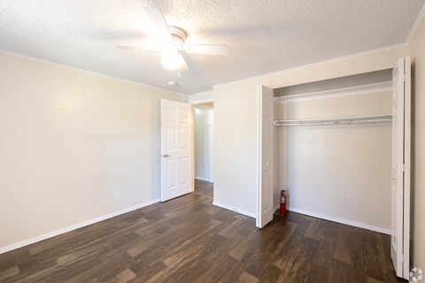 A room with a ceiling fan and wooden flooring.
