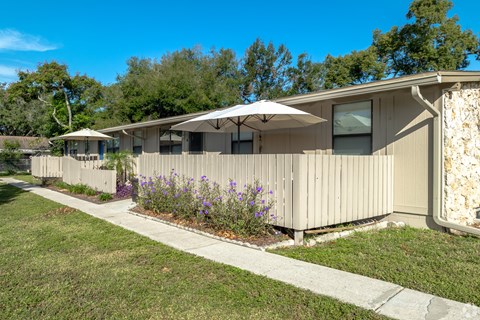 A row of houses with a sidewalk and a lawn in front.