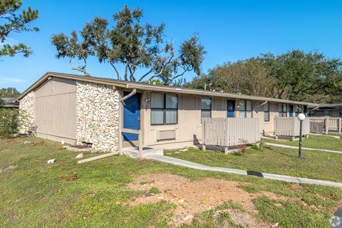 A house with a stone wall and a blue door.