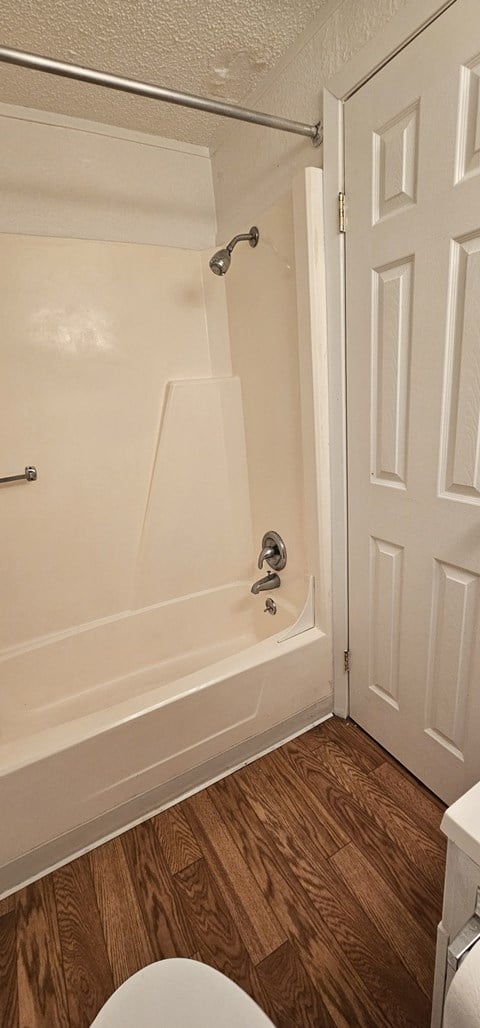a bathroom with a tub and a toilet and a door