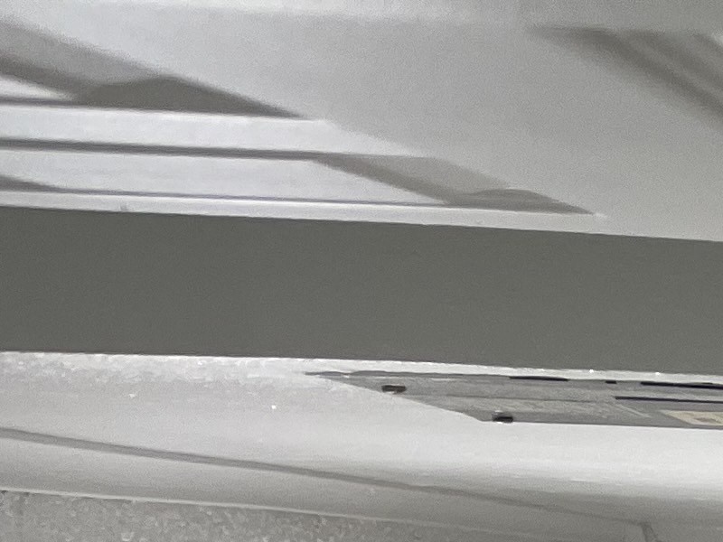 A small, white, enclosed space with a vent on the wall.