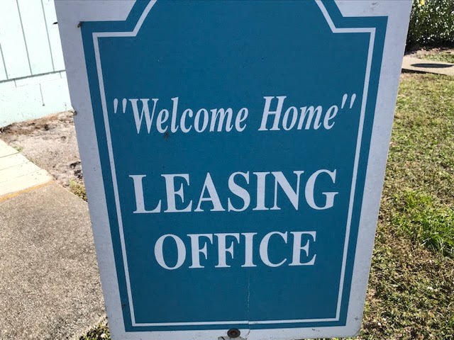 a blue sign that reads welcome home leasing office