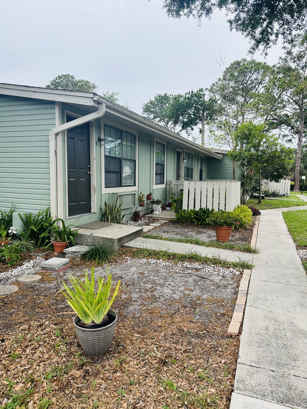 a small blue house with a sidewalk in front of it