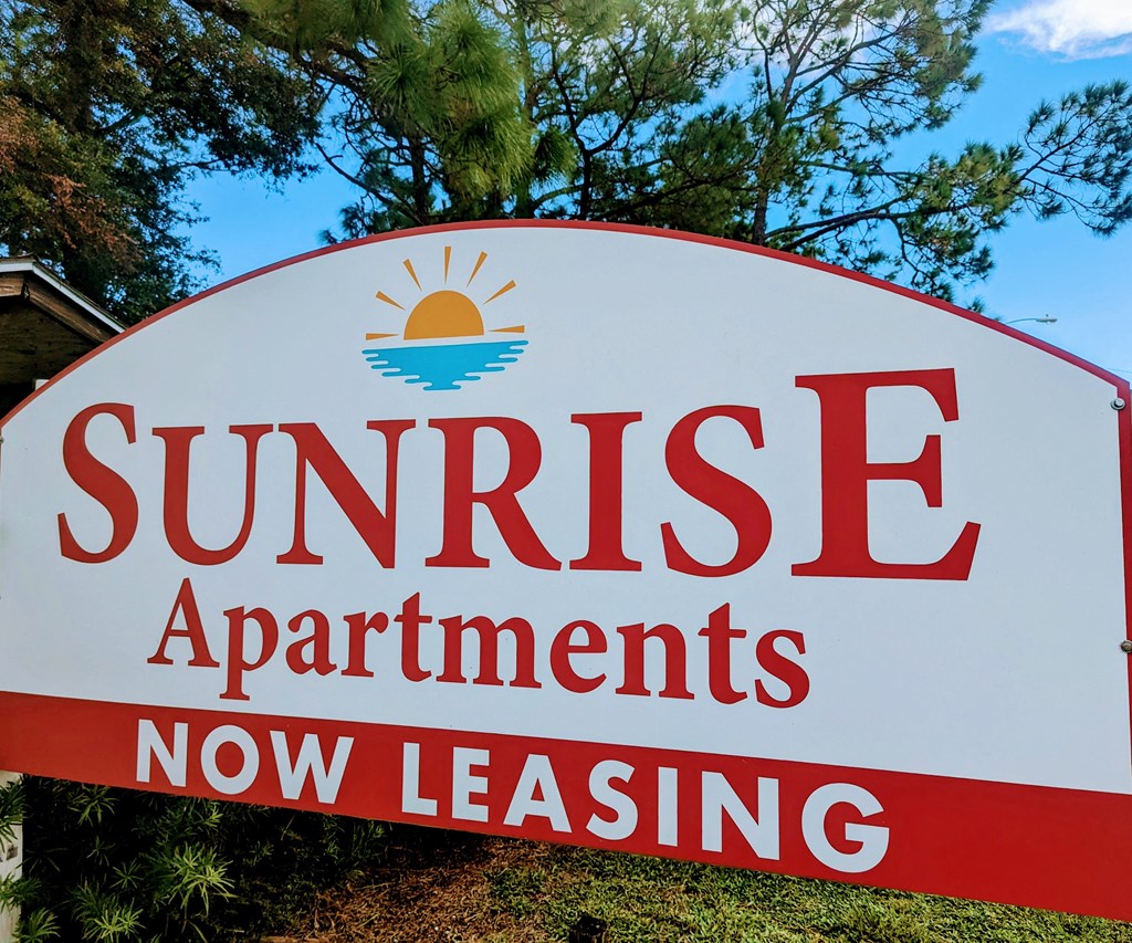 a sign that reads sunrise apartments now leasing