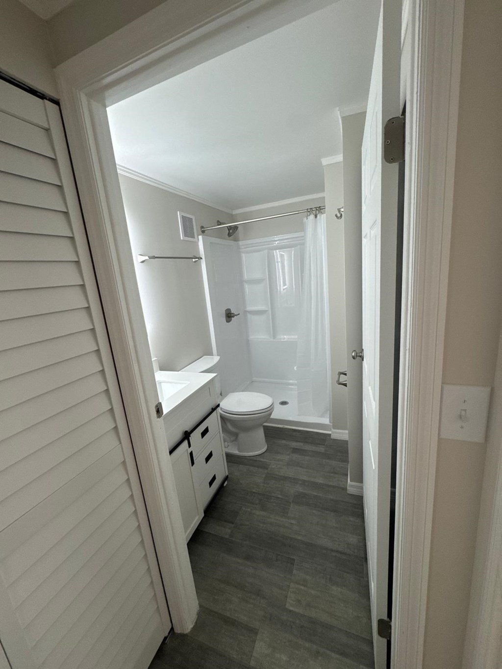 A bathroom with a toilet, sink, and shower.