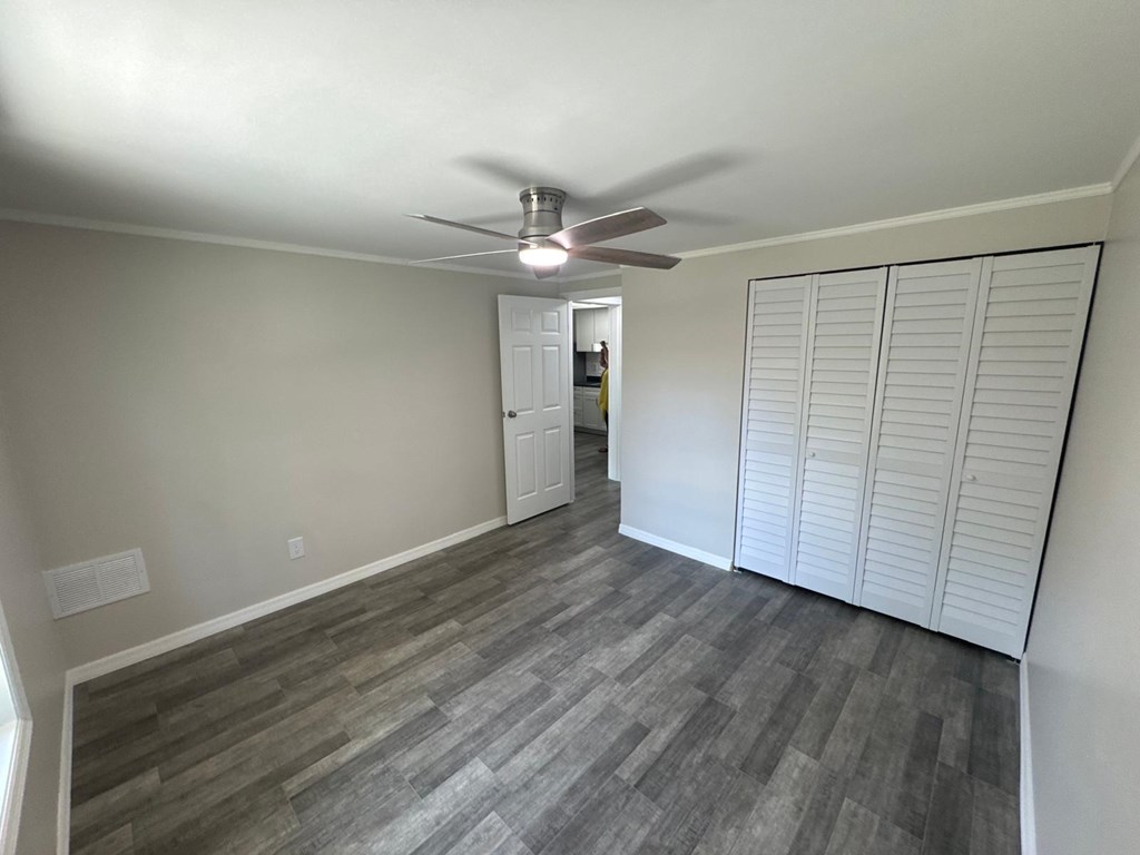 A room with a ceiling fan and a door.
