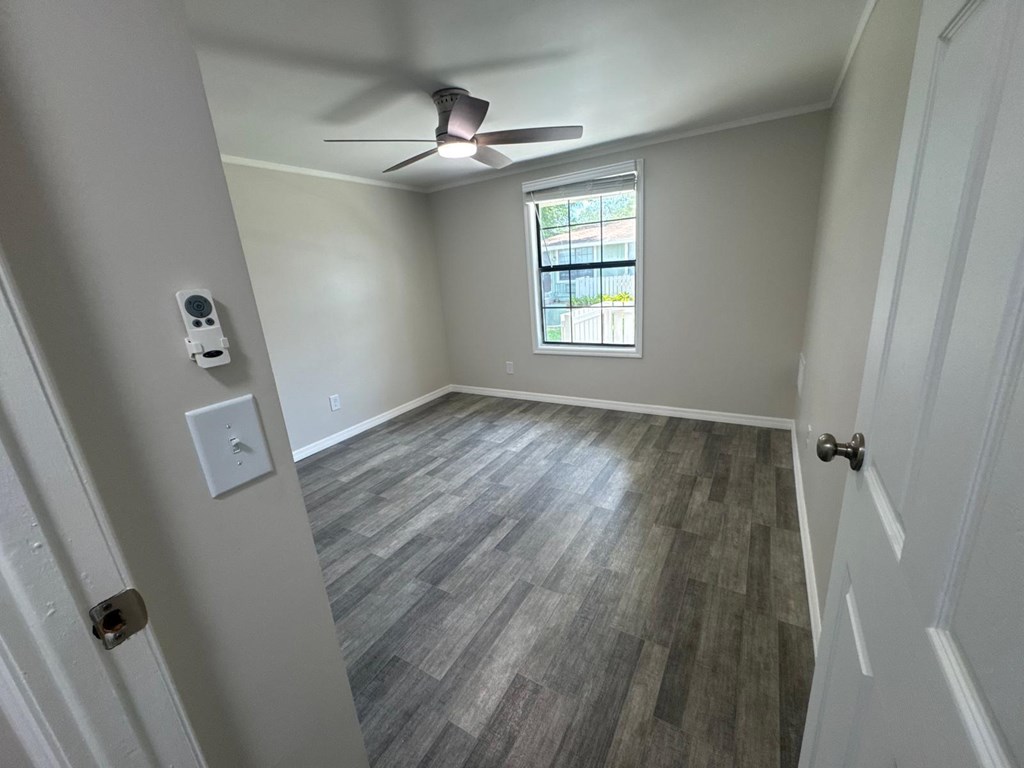 A room with a ceiling fan and a window.