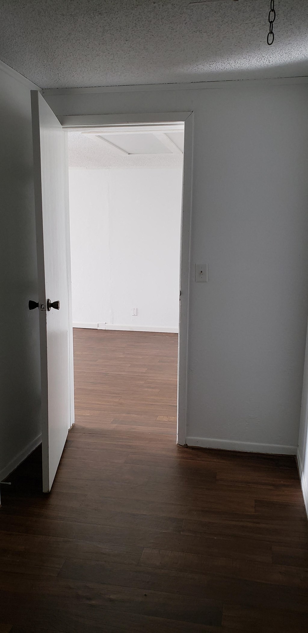 an empty room with wooden floors and a white door