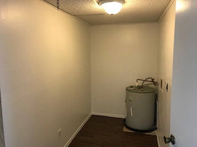 an empty room with a water heater in the corner