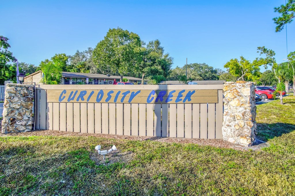 a sign that reads chicken creek in front of a fence