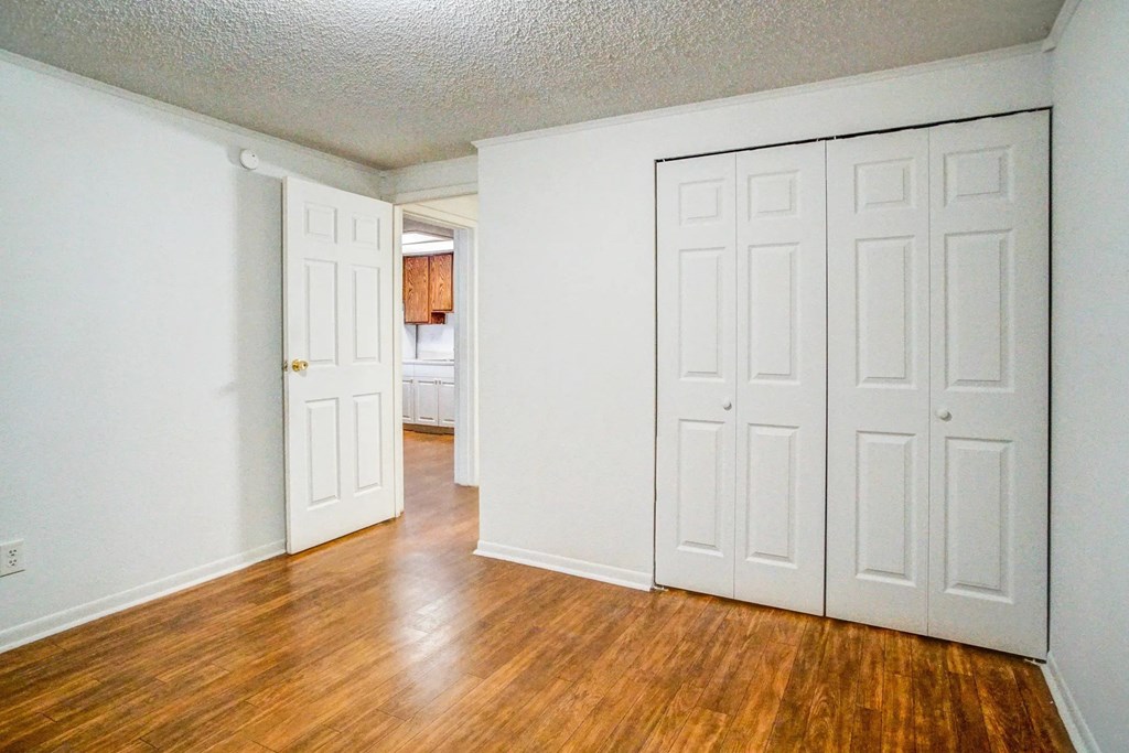 an empty living room with white walls and wood floors