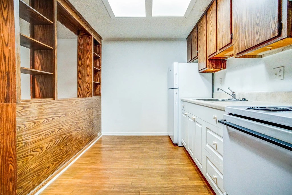 a kitchen with white appliances and wooden cabinets