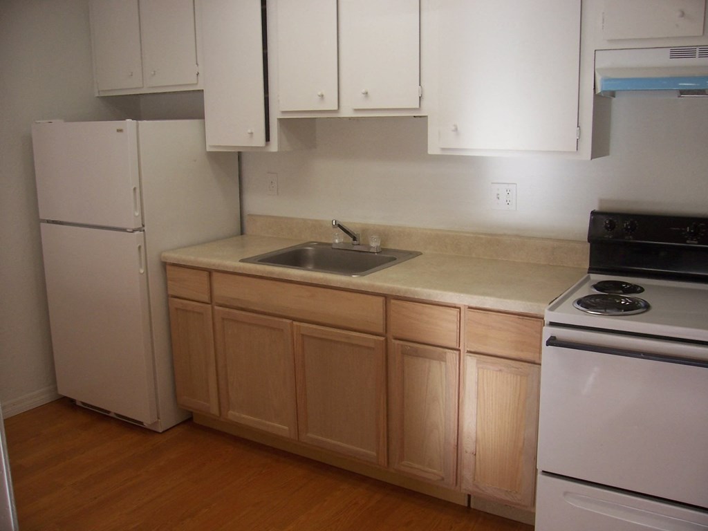 a kitchen with white appliances and wooden cabinets