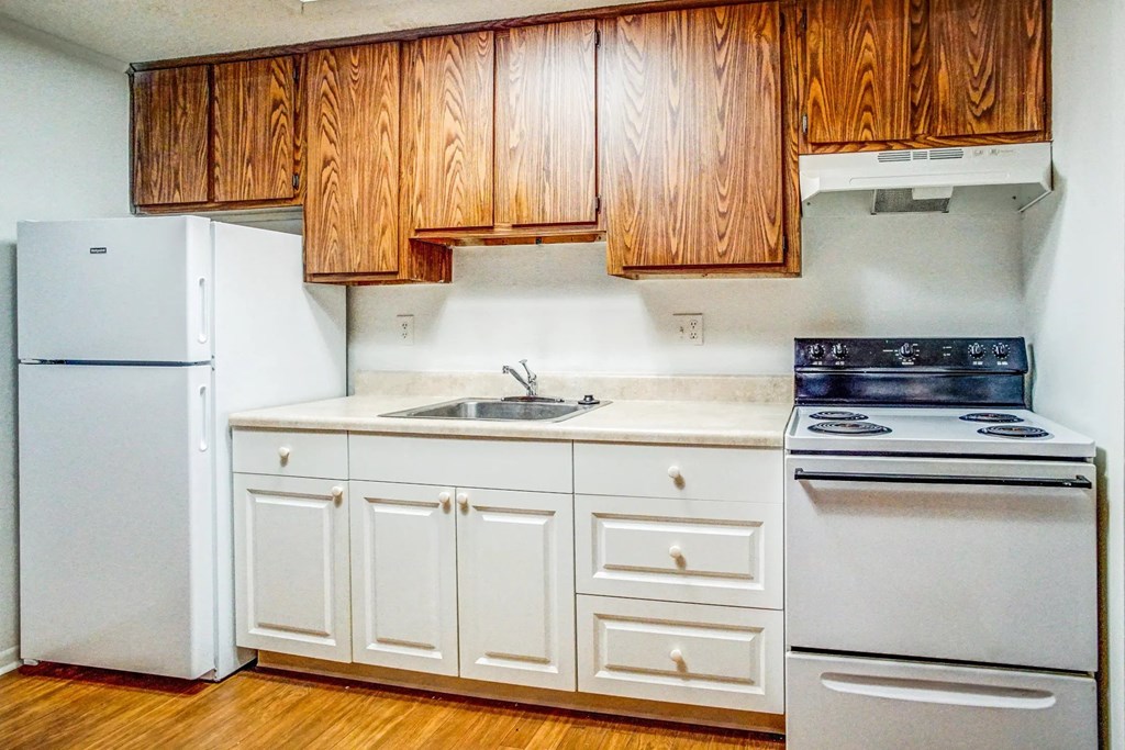 a kitchen with white appliances and wooden cabinets