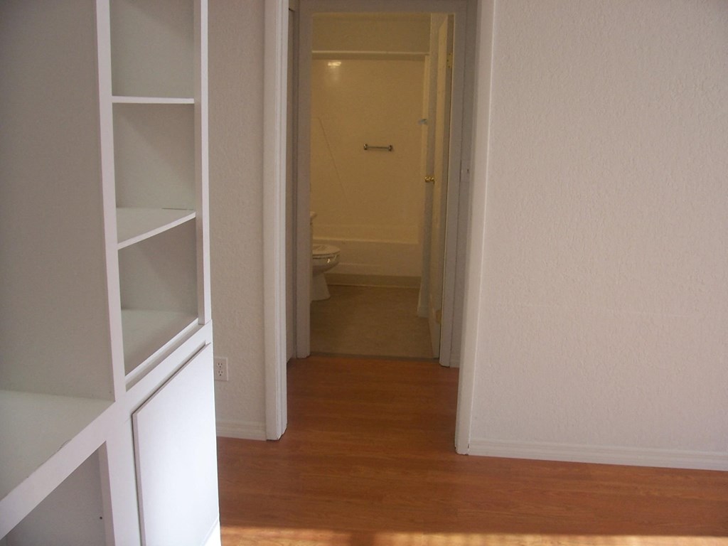 a view of a hallway with a door open to a bathroom