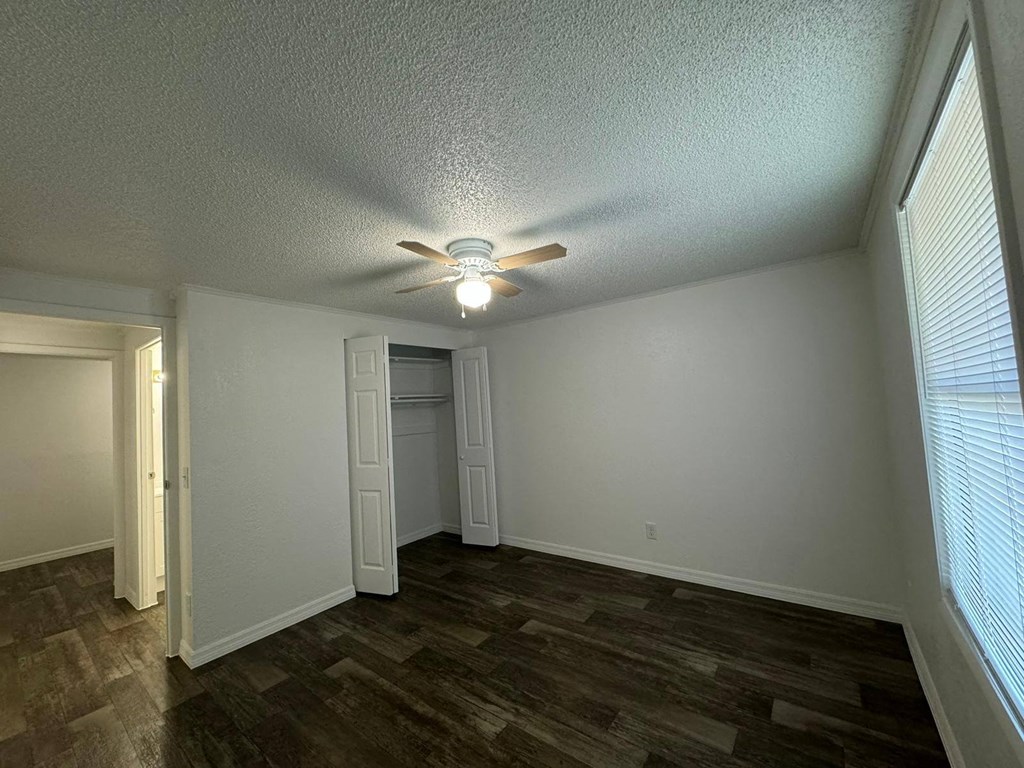 a living room with a ceiling fan and a door to a closet