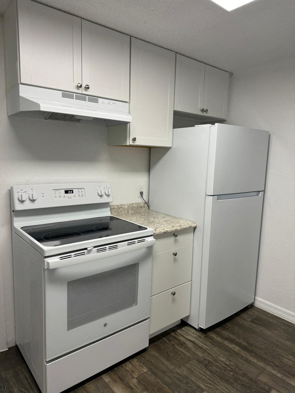 a kitchen with white appliances and a refrigerator