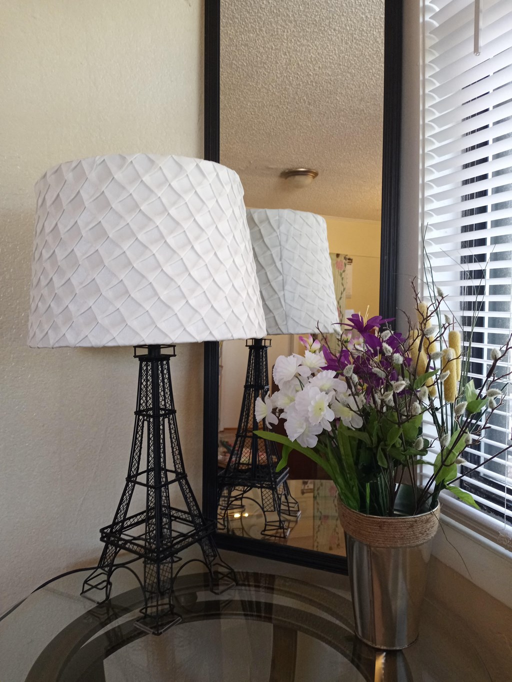 a table with a lamp and a vase with flowers on it