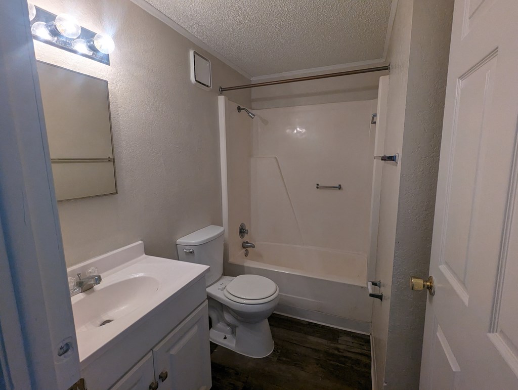 a bathroom with a toilet and a sink and a shower
