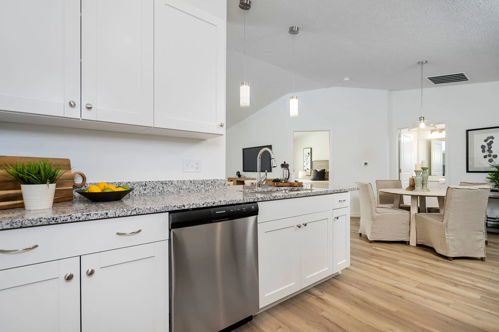 A modern kitchen with white cabinets and a wooden countertop.