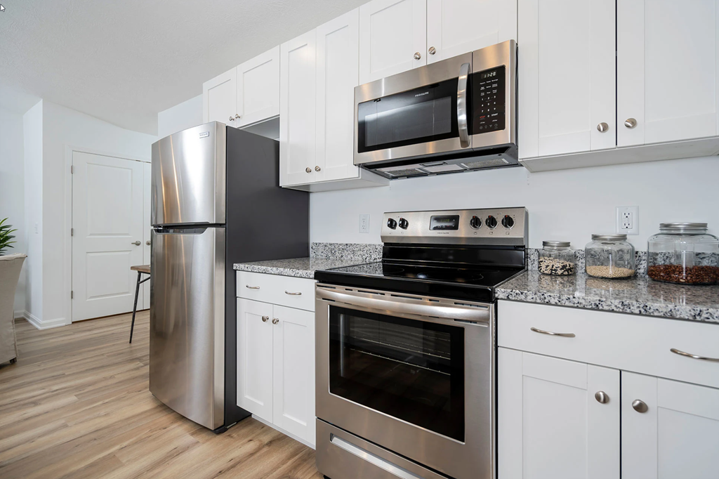 A modern kitchen with stainless steel appliances and white cabinets.