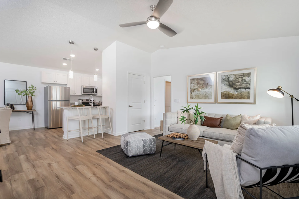 A modern living room with a grey couch and a wooden floor.