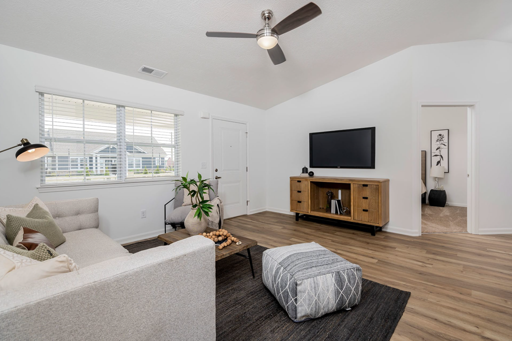 A living room with a grey sofa and a wooden cabinet.