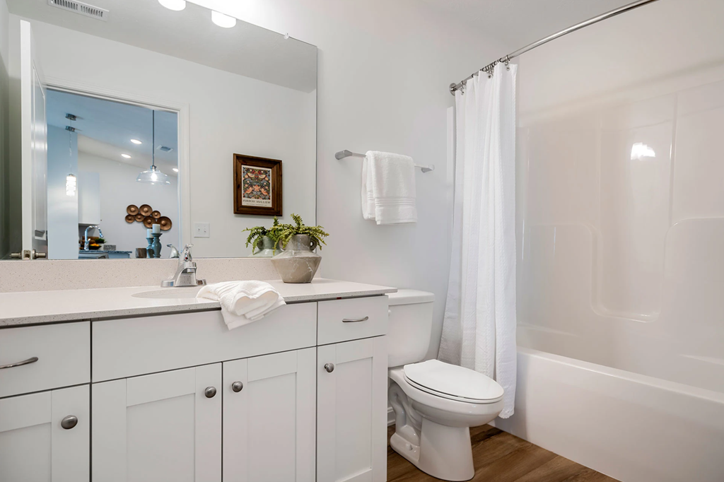 A white bathroom with a toilet, sink, and bathtub.
