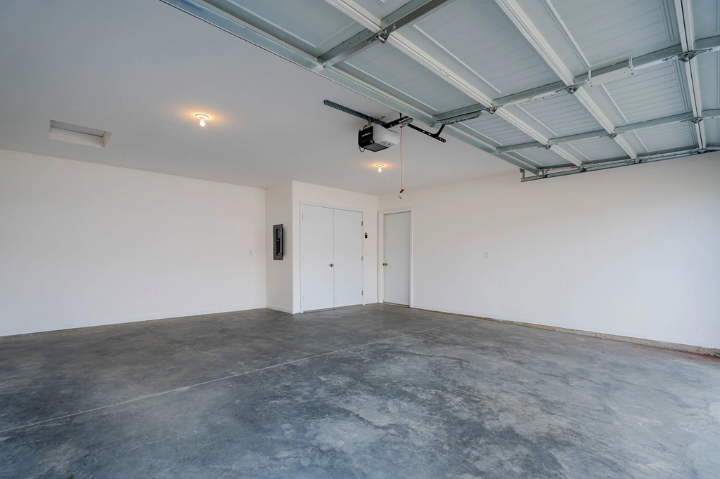 A large empty room with a concrete floor and a ceiling with exposed beams.