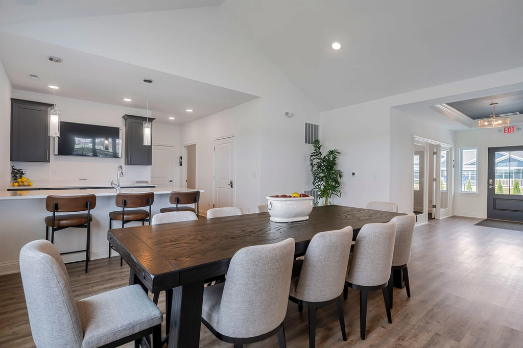 A dining room with a wooden table and grey chairs.