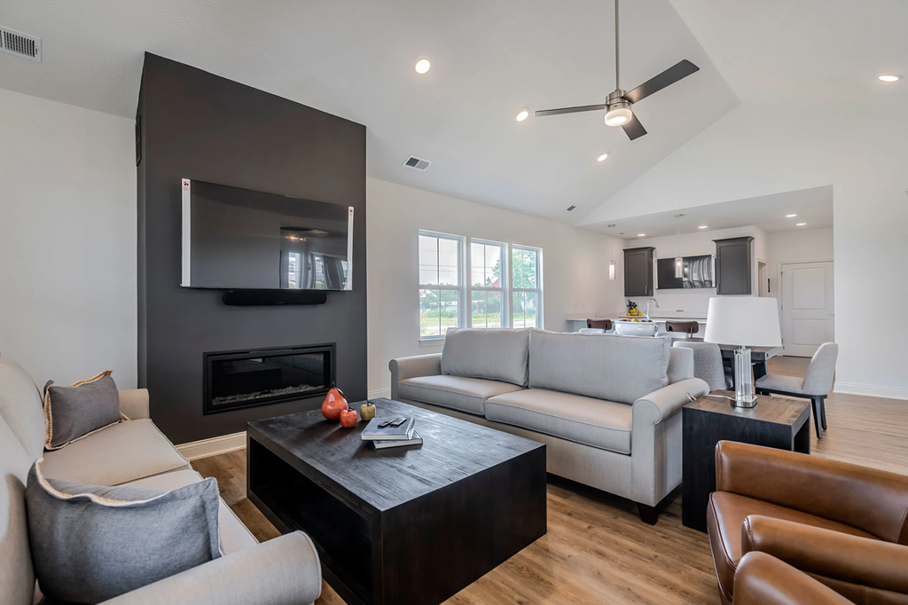 A modern living room with a fireplace and a grey sofa.