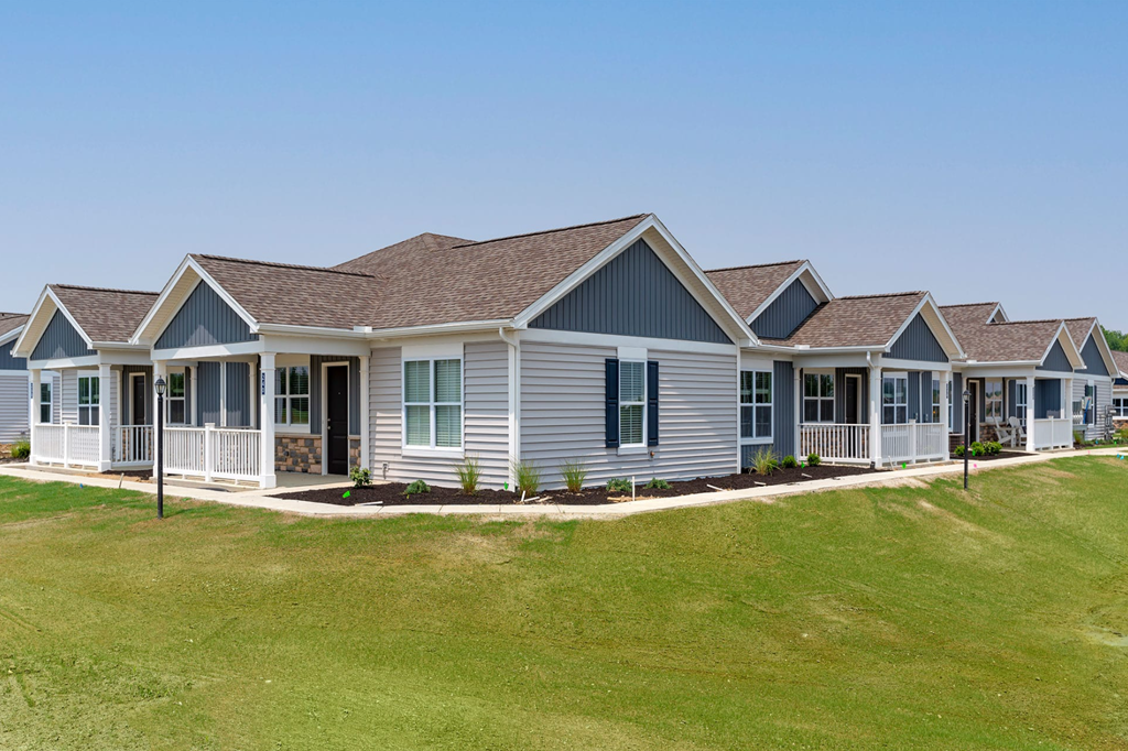 A row of houses with a green lawn in front.