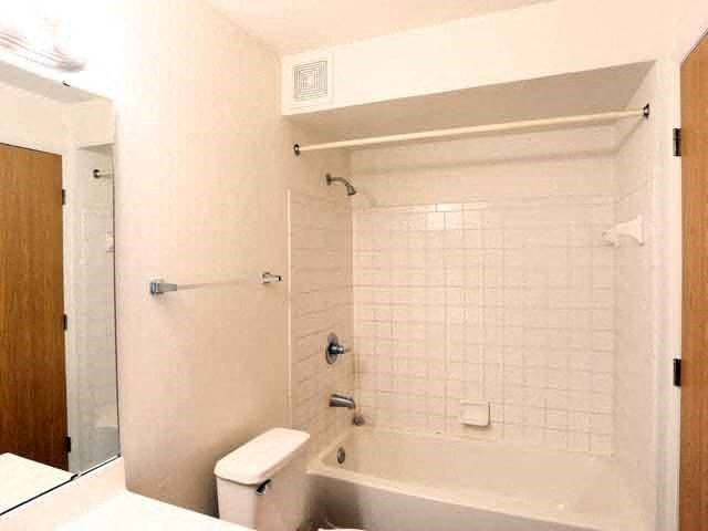 a white bathroom with a tub and a toilet