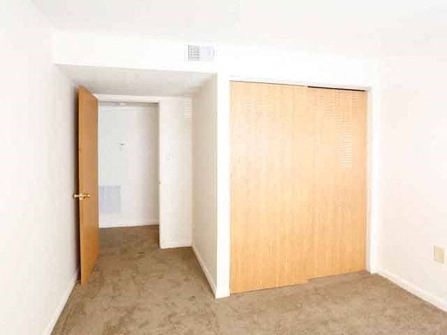 an empty room with an open door and a closet