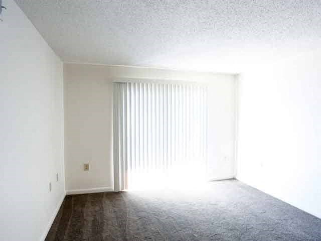an empty living room with white walls and a window
