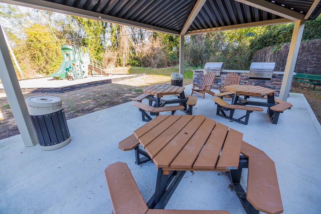 our picnic tables are under the pavilion with a playground in the background at Broadway at East Atlanta, Atlanta