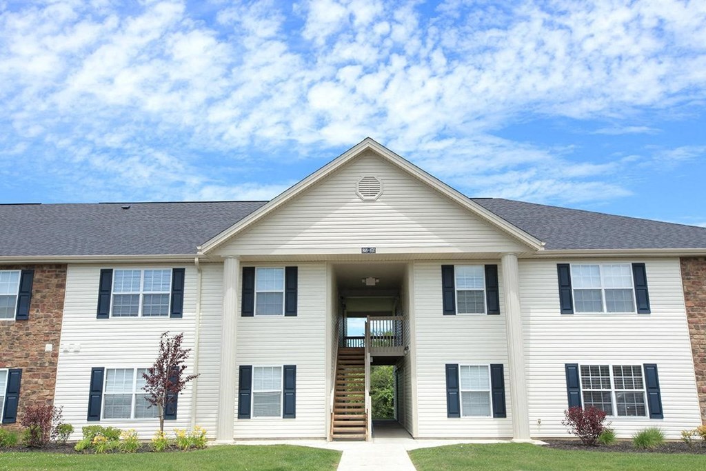 the front of a white house with a porch