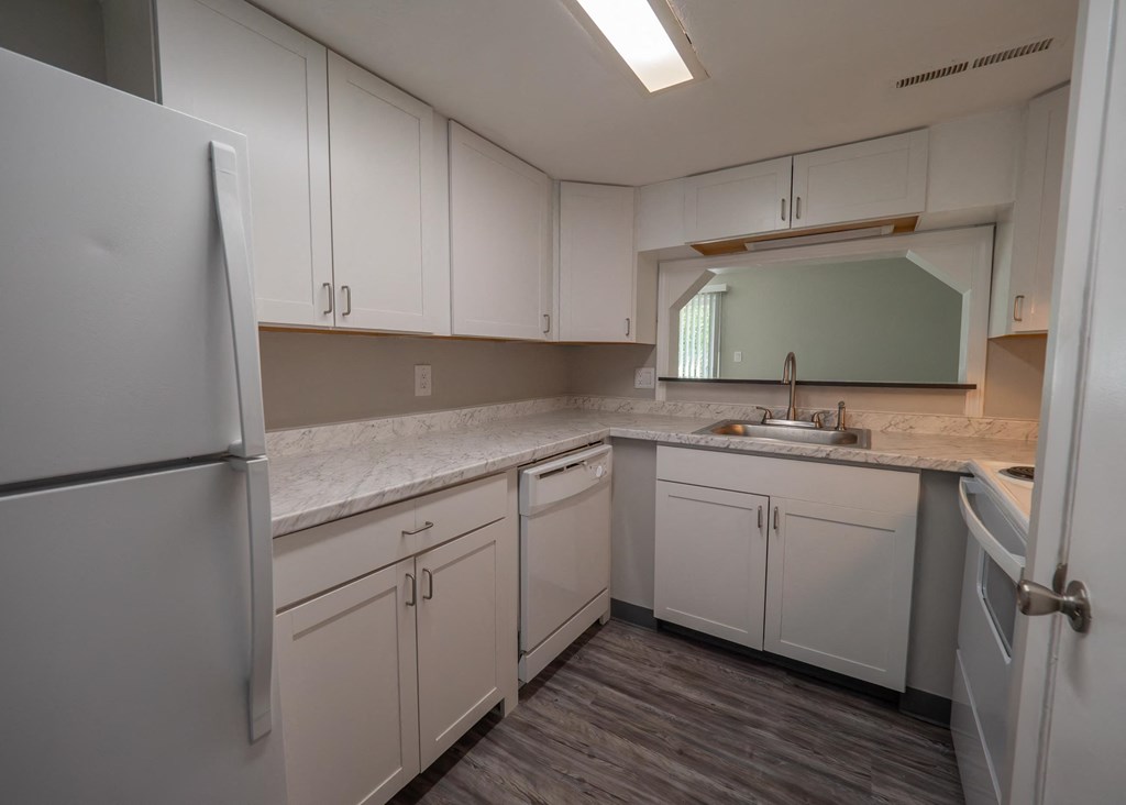 a kitchen with white cabinets and a sink and refrigerator