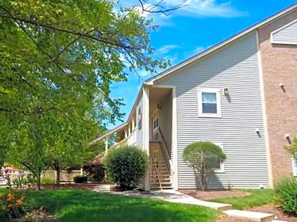 the front of a house with a yard and a tree