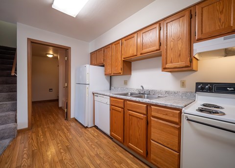 A kitchen with wooden cabinets and a white fridge.