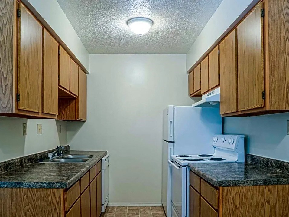a kitchen with a stove refrigerator and sink