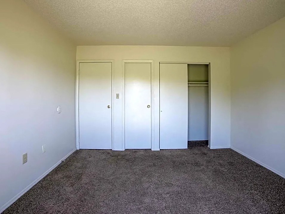 an empty room with three closets on the wall