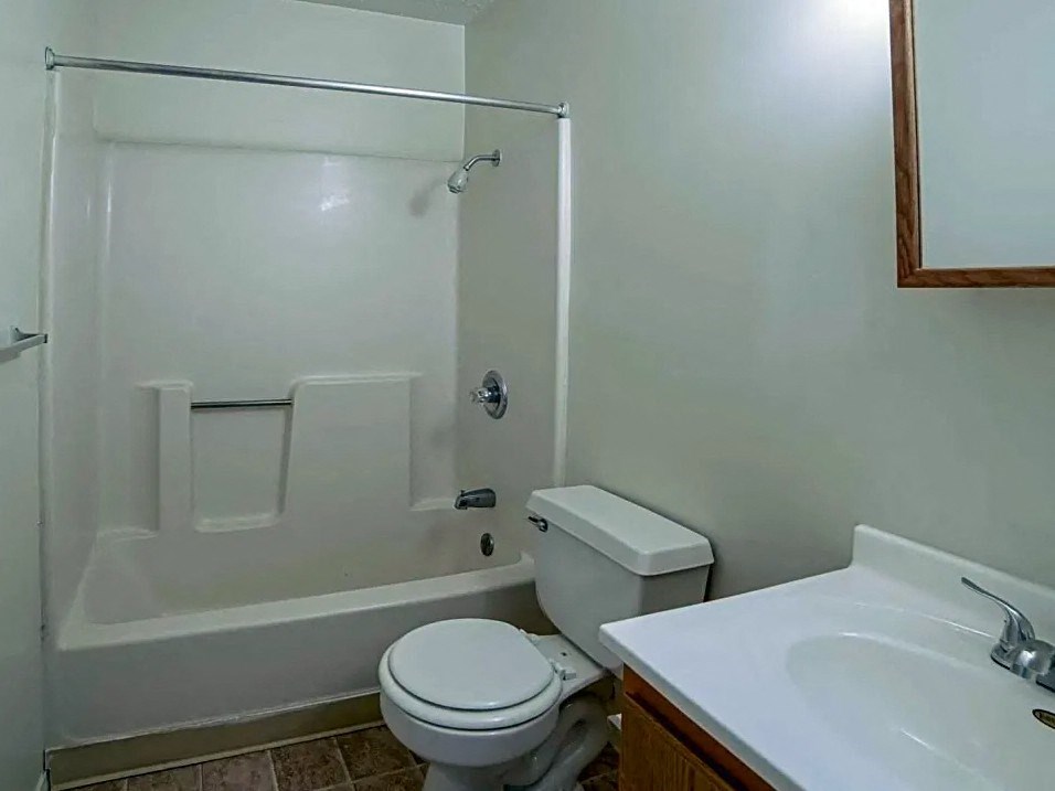 a bathroom with a toilet and a tub and a sink