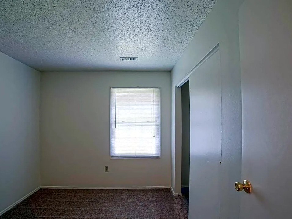 an empty room with a window and a door